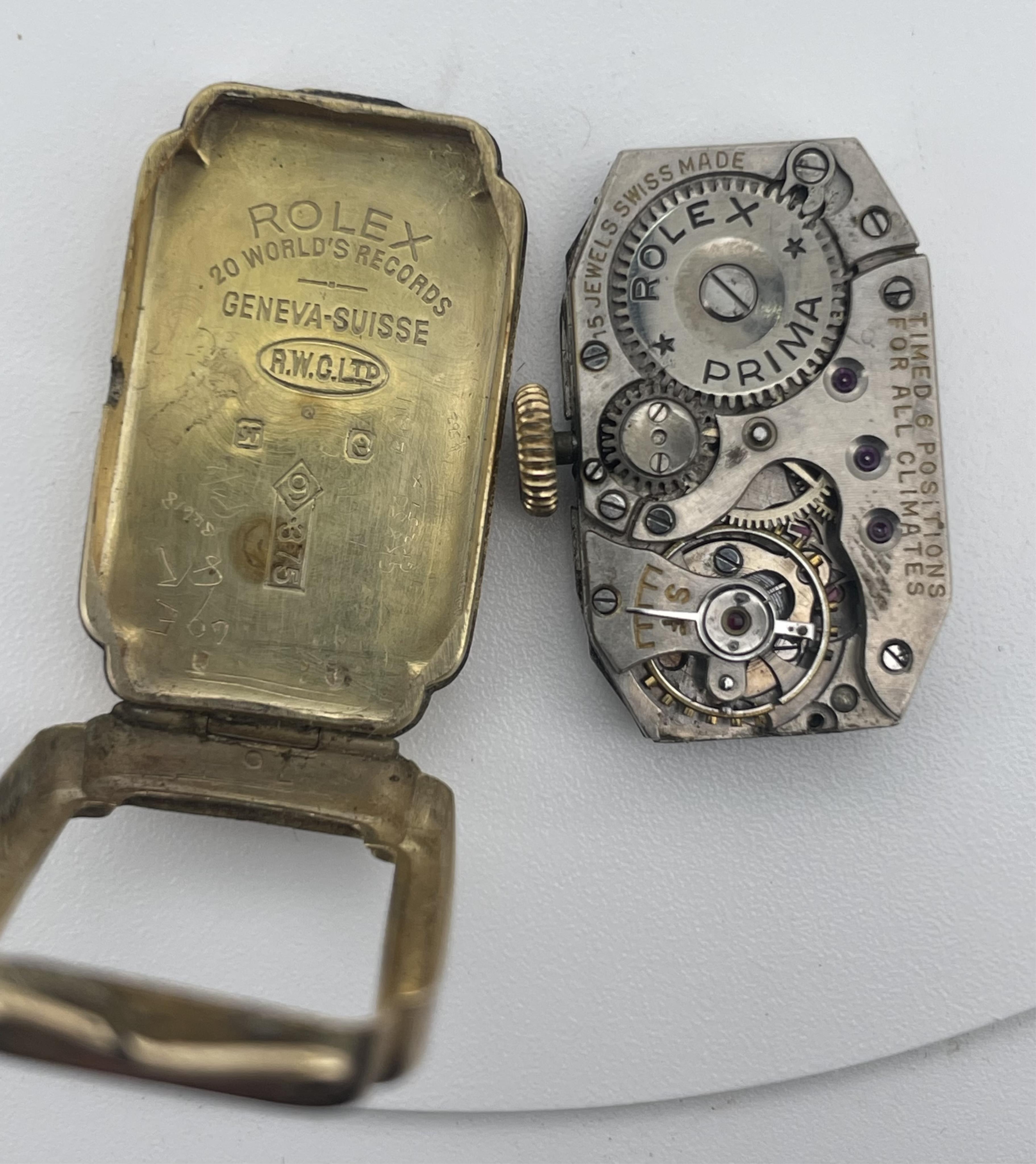Rolex, a lady's 9ct watch, circa 1927, of elongated cross-shaped form, the guilloché dial with Arabic numeral indicators, to a gold case engraved with bands of laurel leaves, length 2.6 x 1.7cm including dial, reverse in